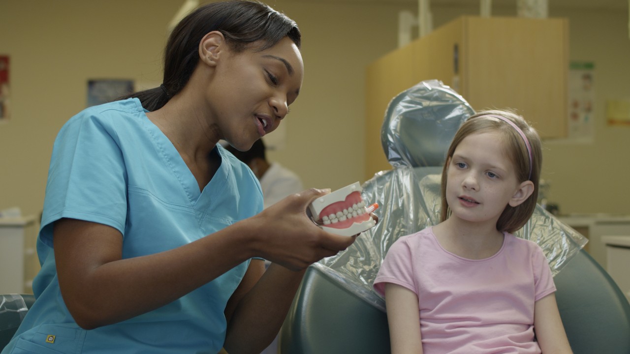 Instructor showing girl how to brush properly